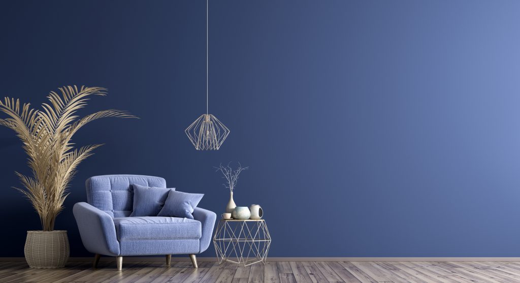 blue wall, grey laminate floor with blue chair, plant, wire lamp and table