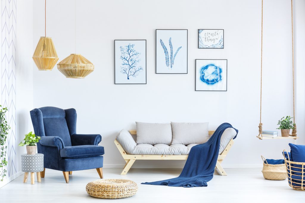 living room with blue blanket, blue chair and blue styled pictures.