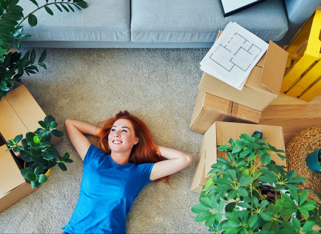 girl lying on new carpet in new home